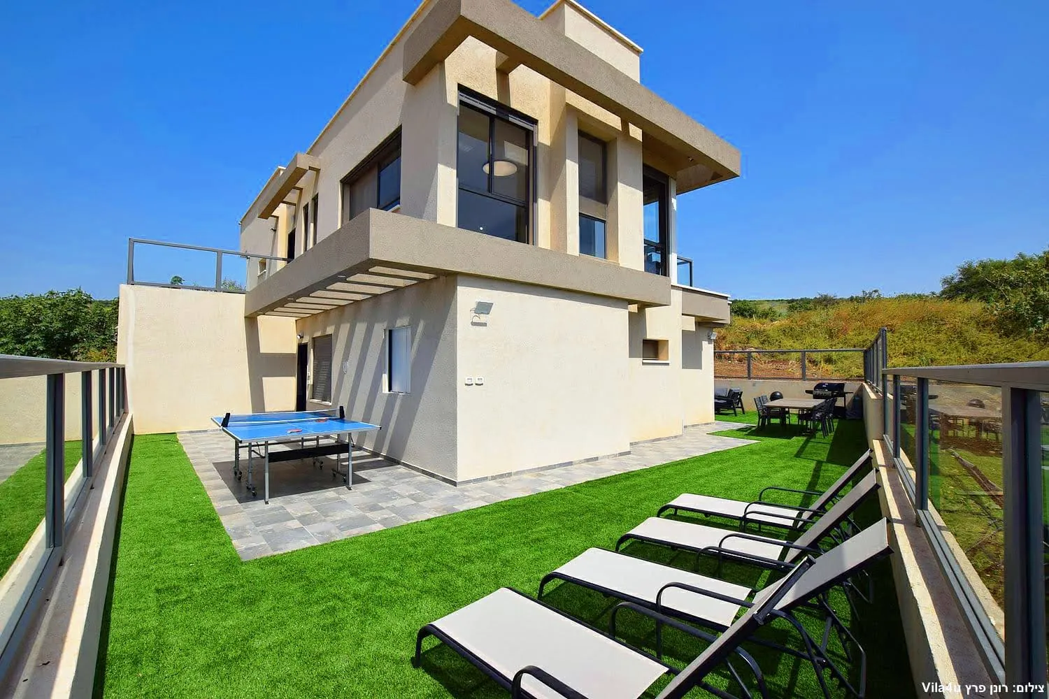 Kinneret House – מדשאה עם מיטות שיזוף ושולחן פינג פונג